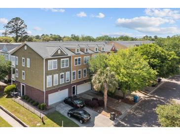 Charming townhomes boast colorful exteriors, garages, and landscaped yards under a sunny sky at 9226 Southern Oak Ln, Ladson, SC 29456