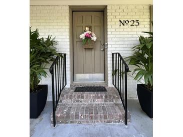 Charming front door entrance with brick steps, black railing, and decorative flower basket with address number above at 23 Hunters Forest Dr, Charleston, SC 29414