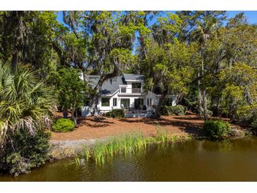 Beautiful exterior view of waterfront home surrounded by lush greenery and trees with Spanish moss at 2455 The Bent Twig, Seabrook Island, SC 29455