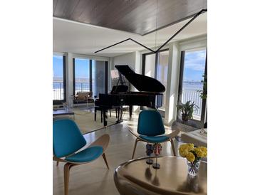 Bright living room featuring a grand piano and water views at 330 Concord St # 12 F&G, Charleston, SC 29401