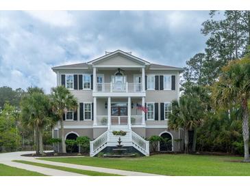 Charming two-story home featuring a symmetrical facade, dual balconies, and a well-manicured lawn at 3547 Holmgren St, Mount Pleasant, SC 29466