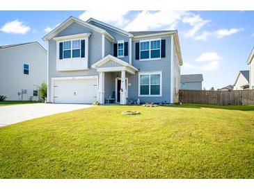 Two-story home featuring light gray siding, black shutters, a well-manicured lawn, and a two-car garage at 613 Ravens Wood Rd, Summerville, SC 29486