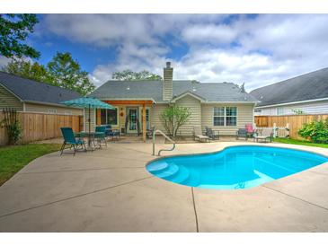Backyard with a refreshing in-ground pool surrounded by a concrete patio and well-maintained landscaping at 1016 Providence Way, Summerville, SC 29483