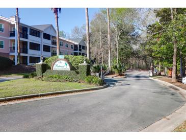 Gated entrance to The Retreat Luxury Condominiums with lush landscaping and multi-story condo buildings in the background at 1025 Riverland Woods Pl # 1023, Charleston, SC 29412