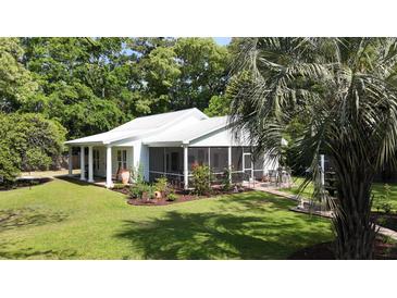 Charming home with screened porch, lush landscaping, and a beautiful lawn at 104 Waccamaw Dr, Summerville, SC 29485