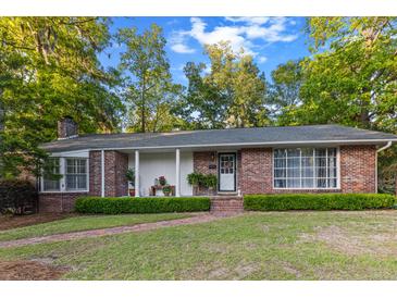 Inviting brick home with a well-manicured lawn, brick path and lush green landscaping around the perimeter at 114 California Ave, Moncks Corner, SC 29461