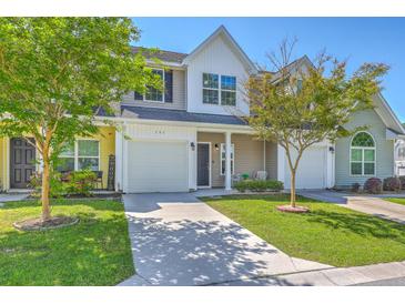 Charming townhome showcases a manicured lawn, and a paved driveway leading to an attached garage at 131 Buchanan Cir, Goose Creek, SC 29445