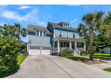 Charming two-story blue home features a welcoming front porch, palm trees, and a two-car garage at 1325 Whisker Pole Ln, Mount Pleasant, SC 29466