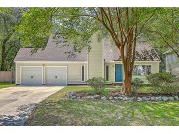 Charming home featuring an attached two-car garage, complemented by a blue front door and a well-maintained front yard at 141 Bridgecreek Dr, Goose Creek, SC 29445
