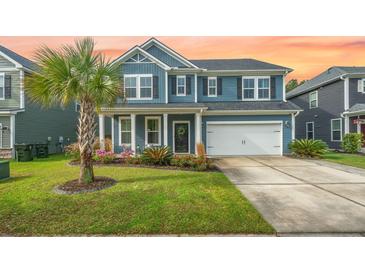 Charming two-story home featuring a well-manicured lawn and a cozy front porch with lush landscaping at 145 Basket Grass Ln, Summerville, SC 29486