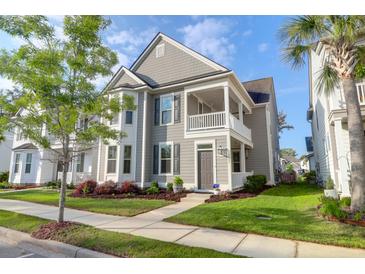 Charming two-story home features a covered porch, well-manicured lawn, and beautiful landscaping at 1907 Mossdale Dr, Johns Island, SC 29455