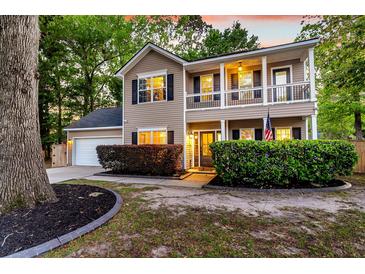 Inviting two-story home featuring a charming front porch, manicured landscaping, and a two car garage at 5400 Rock Creek Ct, North Charleston, SC 29420
