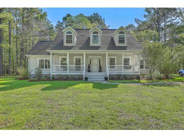 Charming home featuring a welcoming front porch and dormer windows at 5950 Lowell Reed Rd, Ravenel, SC 29470