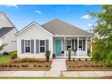 Charming single-story home features a well-manicured lawn, rocking chair porch, and a vibrant, welcoming teal front door at 607 Heartwood Ln, Summerville, SC 29486