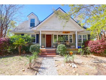 Charming home featuring a welcoming front porch and beautifully landscaped front yard with mature trees and shrubs at 905 Simmons St, Mount Pleasant, SC 29464