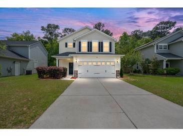 Charming two-story home with well-maintained lawn, a two-car garage and beautiful sunset lighting at 9660 Godwin St, Ladson, SC 29456