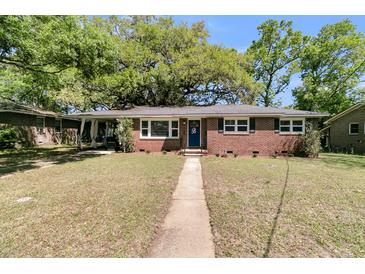 Charming brick home featuring a manicured front lawn and a walkway leading to a blue front door at 1142 Camden St, North Charleston, SC 29405