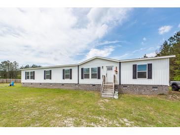 Charming single-story home featuring a white facade, black shutters, and a well-maintained lawn and landscaping at 1330 Whitehouse Rd, Summerville, SC 29486