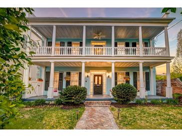 Charming two-story home featuring a spacious porch with columns and manicured landscaping at 154 Wentworth St, Charleston, SC 29401