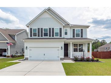 Charming two-story home with a well-manicured lawn, inviting front porch, and a two-car garage at 158 Boots Branch Rd, Summerville, SC 29485