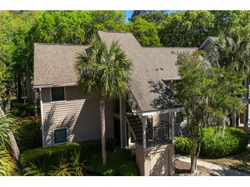 Charming condo with traditional architecture surrounded by lush greenery and a stately palm tree at 160 High Hammock Villas, Seabrook Island, SC 29455
