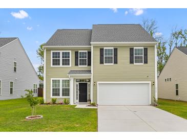 Charming two-story home with a well-manicured lawn and attached two-car garage at 1728 Refuge Dr, Ladson, SC 29456