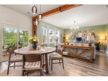 Bright open-concept living and dining area with wood floors and exposed beam at 206 Red Bluff St, Summerville, SC 29483
