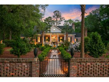 Charming brick home with manicured landscaping and inviting entrance at sunset at 207 Central Ave, Summerville, SC 29483