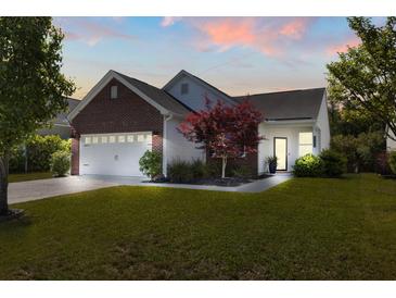 Charming single-Gathering home with brick and siding, showcasing a well-manicured lawn and attached two-car garage at 3133 Cold Harbor Way, Charleston, SC 29414