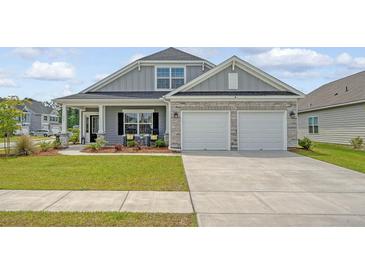 Charming home featuring stone accents, a covered porch, and a two-car garage in a well-manicured community at 317 Fiddleback Dr, Summerville, SC 29486