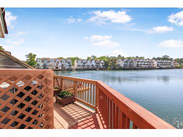 Relaxing deck view overlooking the serene water and surrounding townhouses, providing a peaceful outdoor living space at 4735 Arco Ln, North Charleston, SC 29418