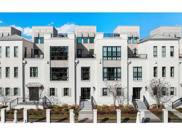 Modern townhome showcases a sleek white facade, black-framed windows, and a well-manicured front yard at 508 Helmsman St, Charleston, SC 29492