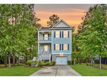 Charming two-story home with a double porch, beautiful trees, nice landscaping, and driveway leading to a garage at 521 Sanders Farm Ln, Wando, SC 29492
