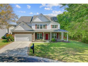 Charming two-story home featuring a brick facade, covered porch, and well-manicured front lawn at 9609 Portal Ct, Summerville, SC 29485