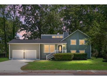 Charming two-story home with attached two-car garage and manicured lawn under a twilight sky at 105 Brailsford Rd, Summerville, SC 29485