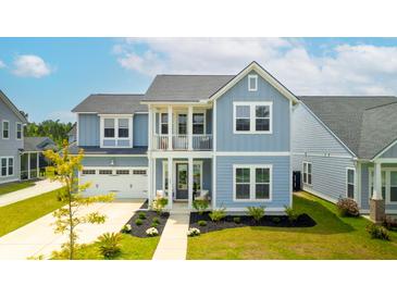 Charming two-story blue home with a welcoming front porch and well-manicured lawn at 127 Archdale St, Summerville, SC 29486