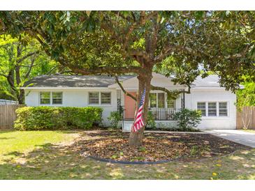Charming single-story white brick home with lush landscaping and a quaint front yard tree at 1303 Teal Ave, Charleston, SC 29412