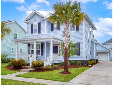 Charming two-story home with a landscaped yard and inviting front porch featuring a palm tree at 1488 Croaton Crsg, Mount Pleasant, SC 29466