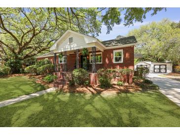 Charming brick home with a landscaped front yard and covered porch with decorative iron details at 1514 Gardenia Rd, Charleston, SC 29407