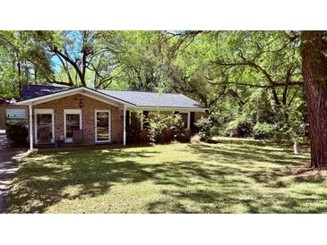 Charming brick home with mature trees and inviting front yard offering curb appeal at 1521 Camp Rd, Charleston, SC 29412