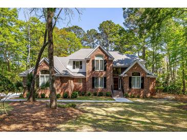 Charming brick home with manicured lawn and lush landscaping, creating a welcoming curb appeal at 1855 Cherokee Rose Cir, Mount Pleasant, SC 29466