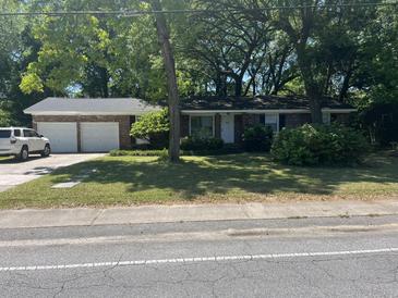 Charming single story brick home with an attached two car garage and mature trees at 1866 Ashley Hall Rd, Charleston, SC 29407