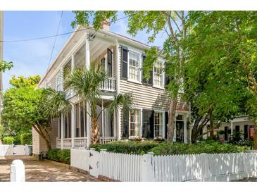 Charming two-story home with a white picket fence and lush landscaping, perfect for curb appeal at 23 Savage St, Charleston, SC 29401