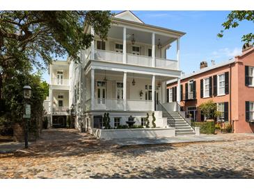 Elegant two-story home boasting a charming double porch, symmetrical columns, and well-manicured landscaping at 24 Chalmers St, Charleston, SC 29401