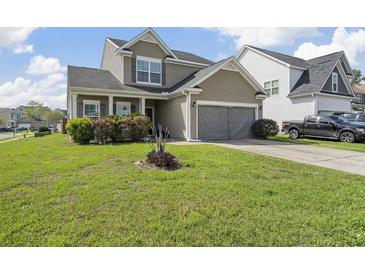 Charming two-story home featuring a well-manicured lawn and attached two-car garage at 2911 Penobscot Dr, North Charleston, SC 29420