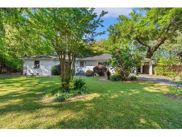 Charming one-story home with a well-manicured lawn and mature trees offering shade and curb appeal at 2988 Bolton Rd, Charleston, SC 29414