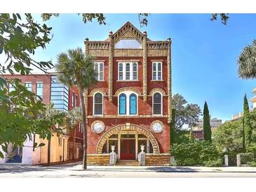 Unique brick building with ornate architectural details and arched windows, set in a vibrant neighborhood at 309 Meeting St # 8, Charleston, SC 29401