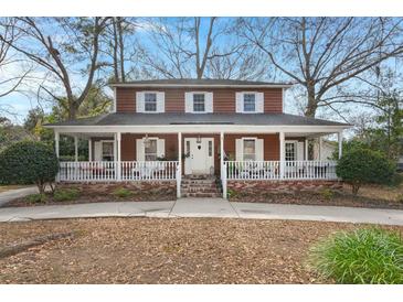 Inviting two-story home featuring a charming wrap-around porch and classic white trim, perfect for relaxing outdoors at 49 Crosscreek Dr, Charleston, SC 29412