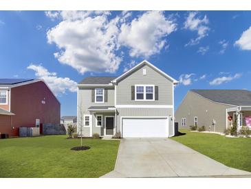 Charming two-story home boasts a well-manicured lawn and attached two-car garage at 819 Casey St, Moncks Corner, SC 29461