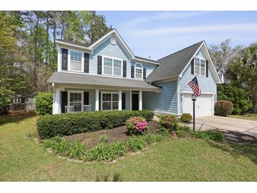 Charming two-story home with an American flag, well-maintained lawn, black shutters, and inviting front porch at 8566 Royal Palm Ln, North Charleston, SC 29420
